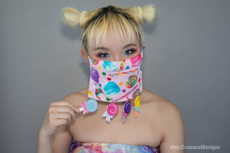 Kawaii Süße Candy Gesichtsmaske Bedeckung Mit Baumelnden Bunten Lollipops von CcseacatDesigns