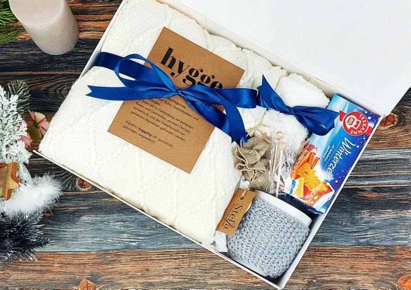 Hygge Harmony Geschenkset Tagesdecke, Wintertee, Tasse Mit Handgestricktem Tassenwärmer Und Flauschigen Socken in Luxuriöser Magnet-Box von StellaGeschenkbox